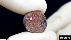 以色列文物保护人员展示考古人员发现的耶路撒冷邑宰印文。（2018年1月1日）
