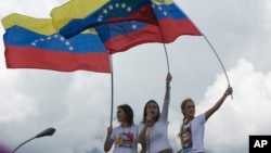 FILE - Patricia Ceballos, wife of jailed opposition leader Daniel Ceballos, left, opposition leader Maria Corina Machado, center, and Lilian Tintori, wife of jailed opposition leader Leopoldo Lopez lead a protest along a main road to demand a recall referendum against Venezuela's President Nicolas Maduro in Caracas, Venezuela, Oct. 22, 2016.