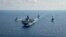 FILE - A Royal Australian Navy guided-missile frigate (L) sails with three US Navy ships in the South China Sea, April 18, 2020. (US Navy photo)