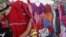 FILE -- A customer looks at PDVSA overalls for sale at a market in Maracaibo, Venezuela, Sept. 11, 2016.