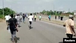 A screen grab shows people running during a protest in Abuja, Nigeria, Sept. 28, 2021. 