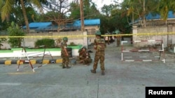 FILE - Security personnel investigate at the site of an explosion in Sittwe, Rakhine state, Myanmar, Feb. 24, 2018, in this picture obtained from social media. (Courtesy of Ministry of Information Webportal Handout/via Reuters)