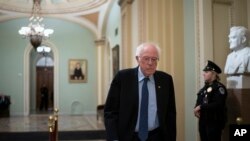 Democratic presidential candidate, Sen. Bernie Sanders, I-Vt., leaves the Senate chamber during a break as the impeachment trial of President Donald Trump on charges of abuse of power and obstruction of Congress stretches into the night, in Washington, Ja