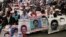 FILE - Relatives of 43 missing students missing since they were taken by local police in September 2014 hold photos of their loved ones, April 24, 2016. Mexico's President Enrique Pena Nieto signed a law Thursday aimed at addressing the country's unsolved disappearances by creating a National Search System with local branches in the states.