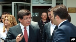Turkish Foreign Minister Ahmet Davutoglu talking to an adviser, in Ankara, June 24, 2012, in this image made available by the Turkish Foreign Ministry. 