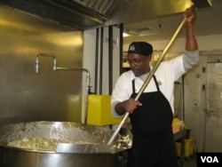 Production cook Gregory Jones uses a paddle to stir up turkey casserole at the DC Central Kitchen. (VOA/R. Skirble)