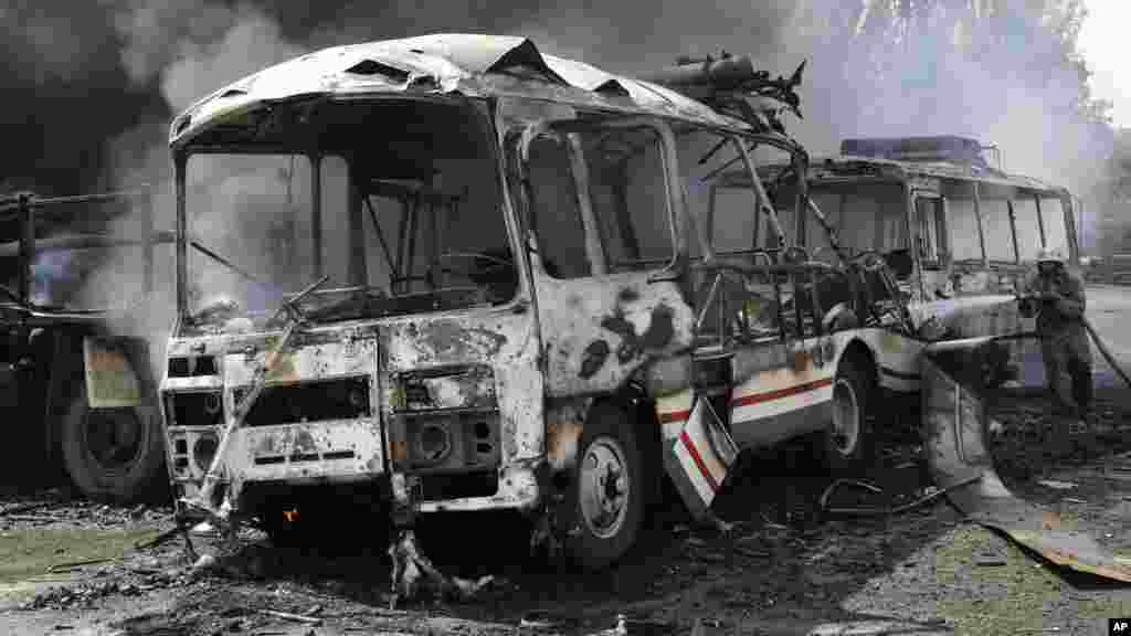 Ukrainian fire fighters put out the fire at the destroyed buses after shelling in Donetsk, eastern Ukraine, Aug. 10, 2014. 