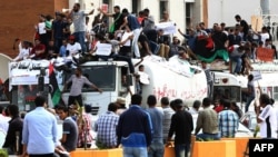 Libyan protesters hold placards and banners during a demonstration in support of the "political isolation law" in Libya's landmark Martyrs Square on May 5, 2013 in Tripoli, Libya. 