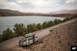 A family stops at Isli lake, one of two famous lakes in the region, during the annual festival of Imilchil, a small village in Morocco's Atlas Mountains, Sept. 22, 2017.
