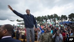 Le président rwandais Paul Kagame salue de la main une foule avant un meeting populaire à Kinigi, dans le nord du Rwanda.