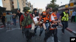 Fuerzas de seguridad israelíes y paramédicos transportan un hombre judío herido que recibió un disparo durante violentos enfrentamientos en Lod, Israel, el 13 de mayo de 2021.