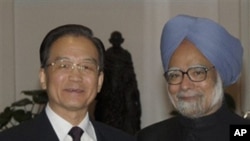 Chinese Premier Wen Jiabao, left, shakes hands with Indian Prime Minister Manmohan Singh during a dinner hosted by the later in New Delhi, India, Wednesday, Dec. 15, 2010.