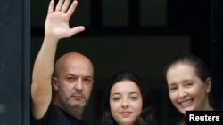 El excomisionado de la policía de Caracas, Iván Simonovis (L), saluda junto a su hija Ivana y su esposa Bony Pertinez en su casa en Caracas. Foto de archivo.