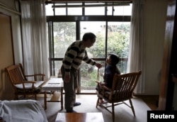 Kanemasa Ito, 72, and his 68-year-old wife Kimiko, who was diagnosed with dementia 11 years ago, chat at their home in Kawasaki, south of Tokyo, Japan, April 6, 2016.