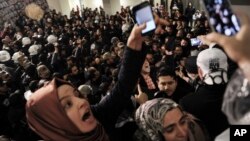 Journalists react as riot police enter the headquarters of Turkey's largest-circulation newspaper Zaman in Istanbul, March 4, 2016. The police raid came hours after a court placed it under the management of trustees on Friday. 