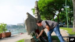 Victor Ramos, a Mexican man who has been living California for the past 35 years, lays flowers at the monument of U.S. Senator John McCain in Hanoi, Vietnam, Aug. 27, 2018.
