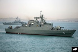 FILE - in photo released by semi-official Fars News Agency, Iranian warship Alborz, foreground, prepares before leaving Iran's waters.