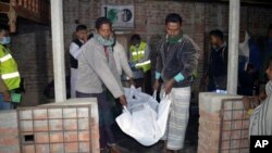 Les services de secours enlèvent un corps après une explosion à Bagmara, district Rajsahi, le Bangladesh, 25 décembre 2015.