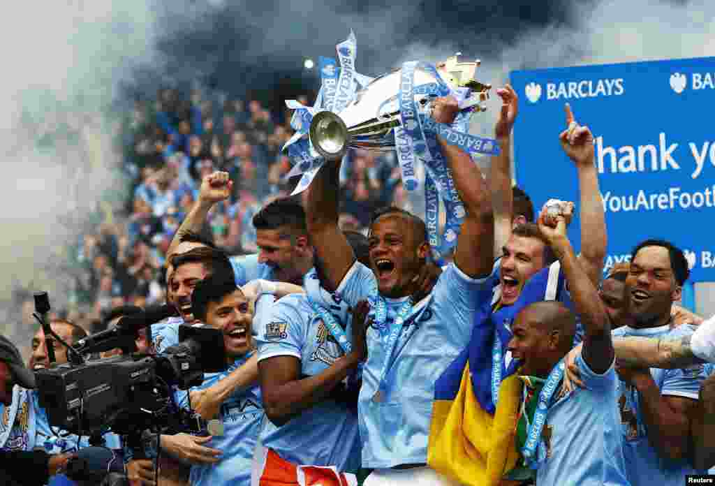 Manchester City&#39;s captain Vincent Kompany (C) celebrates with the English Premier League trophy following their soccer match against West Ham United at the Etihad Stadium in Manchester, northern England.