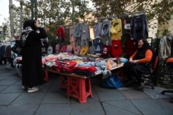A street vendor talks with a customer in downtown Tehran, Iran, Nov. 1, 2021. As U.S. sanctions and the coronavirus pandemic wreak havoc on Iran's economy, suicides in the country increased by over 4%, according to a government study cited by the reformist daily Etemad.
