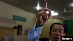 Perdana Menteri Kamboja dan Presiden Partay Rakyat Kamboja, Hun Sen, memperlihatkan jarinya yang bertinta dalam pemilihan Senat di Takhmao, Provinsi Kandal province, Kamboja, 25 Februari 2018.