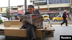 A man reads a newspaper as he sits on a bench in Sur district of the Kurdish-dominated southeastern city of Diyarbakir, Turkey, Oct. 30, 2015. 