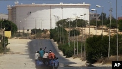A truck carrying Libyan rebel fighters drives towards the Zawiya oil refinery in Zawiyah, August 17, 2011