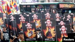 Các nhà hoạt động tham gia vào một buổi tụ họp ủng hộ người Tây Tạng ở Đài Bắc đang trưng hình những người Tây Tạng tự thiêu, 10/3/2013.