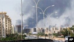 Photo d’archives : Des colonnes de fumée s'élevant de plusieurs sites sur la route de l'aéroport international de Tripoli, en Libye, au cours des combats violents entre milices rivales 