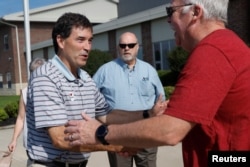 Republican candidate Troy Balderson, in Ohio's 12th congressional district, shakes hands with a voter at a polling station during Tuesday's special election in Newark, Ohio, Aug. 7, 2018.