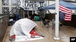 FILE - A protester camps outside the Minneapolis Police Department in this Nov. 17, 2015 photo.
