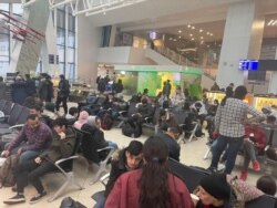 Migran Irak menunggu penerbangan evakuasi di bandara Minsk, Belarus 18 November 2021. (Kantor media/Handout Kementerian Luar Negeri Irak via REUTERS)