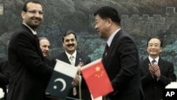 Pakistan's Prime Minister Yousuf Raza Gilani, center, and China's Premier Wen Jiabao, right, clap at a singing ceremony at the Great Hall of the People in Beijing, May 18, 2011