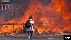 FILE: Zimbabwe's opposition supporters set up a burning barricade as they clash with police during a protest for electoral reforms, Aug. 26, 2016 in Harare, Zimbabwe.