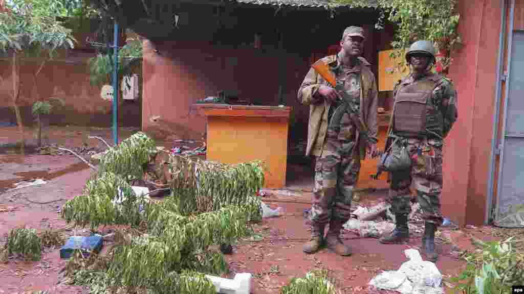 Des soldats du Mali enquête la scène d'une attaque terroriste à l'hôtel Byblos à Sévaré, au Mali, le 11 Août 2015. 