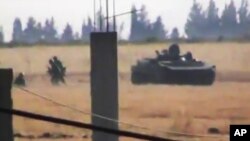 This image made from amateur video released by the Shaam News Network and accessed June 18, 2012, purports to show a Syrian military tank in Daraa, Syria. 