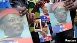 Supporters of former Haitian President Jean-Bertrand Aristide wait outside his house for him to appear on his way to a court appearance, in the Tabarre neighborhood of Port-au-Prince, May 8, 2013. 