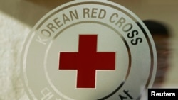 FILE - A man walks past a logo of the South Korean Red Cross at its headquarters in Seoul, Feb. 9, 2011. The International Federation of Red Cross emergency response teams, armed with water pumps, are helping irrigate fields hard hit by North Korea's heat wave.