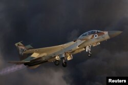 FILE - An Israeli Air Force F-15 fighter jet flies near Hatzerim air base in southern Israel, June 30, 2016. On Saturday, Israeli jets fires missiles at a suspected Iranian military base near the Syrian capital, Damascus.