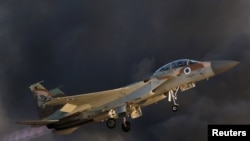 FILE - An Israeli Air Force F-15 fighter jet flies during an aerial demonstration in southern Israel. A series of airstrikes in eastern Syria this week, allegedly by Israel, killed at least 57 people, most of them fighters of Iranian-backed militias.