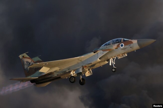 FILE - An Israeli Air Force F-15 fighter jet flies near Hatzerim air base in southern Israel, June 30, 2016. On Saturday, Israeli jets fires missiles at a suspected Iranian military base near the Syrian capital, Damascus.