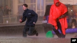 People run as weather sirens sound as a severe storm passes over downtown Dallas, Dec. 26, 2015.