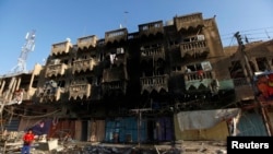 A boy looks at the site of a car bomb attack in a neighborhood of northern Baghdad August 11, 2013.