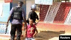 FILE - Policemen detain a protester during clashes in Lubumbashi, Democratic Republic of Congo, Nov. 10, 2015. 