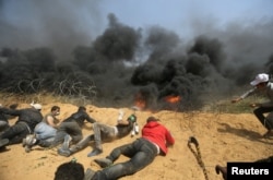 Palestinians remove part of the Israeli fence at the Israel-Gaza border during clashes at a protest demanding the right to return to their homeland, in the southern Gaza Strip, April 6, 2018.