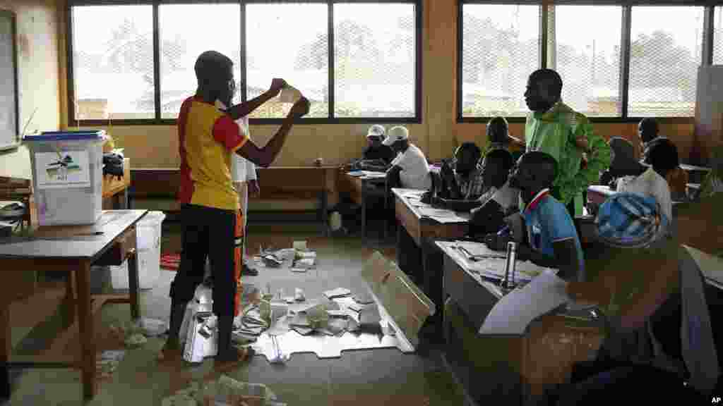 Des responsables des élections contrôlent la conformité au cours du dépouillement des bulletins de vote après la fermeture des bureaux, au deuxième tour de l&#39;élection présidentielle à Bangui, en République centrafricaine, 14 février 2016.