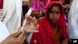 FILE - In this undated GAVI photo, an auxiliary nurse midwife prepares a vaccine shot at a health clinic in Purani Panapur, India.