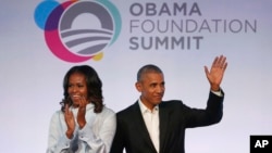 FILE - Former President Barack Obama, right, and former first lady Michelle Obama arrive for the first session of the Obama Foundation Summit in Chicago, Oct. 13, 2017.