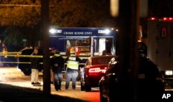 Law enforcement officials investigate at the scene of a shooting, Nov. 2, 2016, in Urbandale, Iowa.