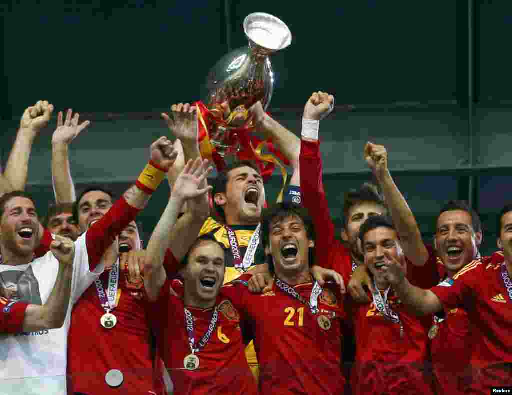 Spain's national soccer players celebrate with the trophy after defeating Italy to win the Euro 2012 final at the Olympic stadium in Kiev, July 1, 2012. 